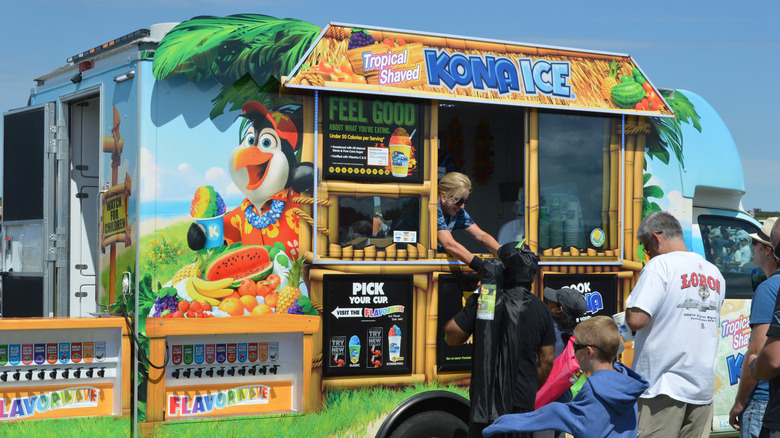 kona ice truck with line outside of it
