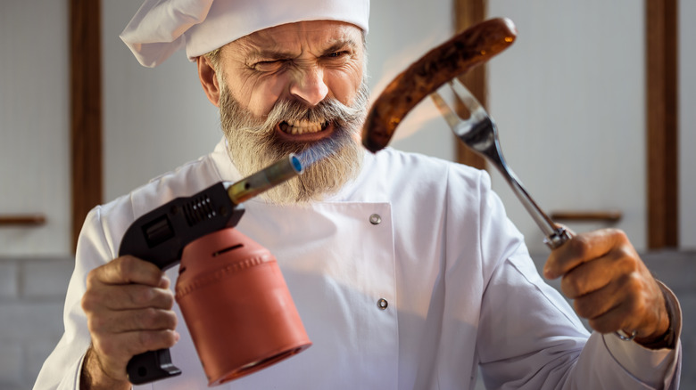 A chef torching a sausage