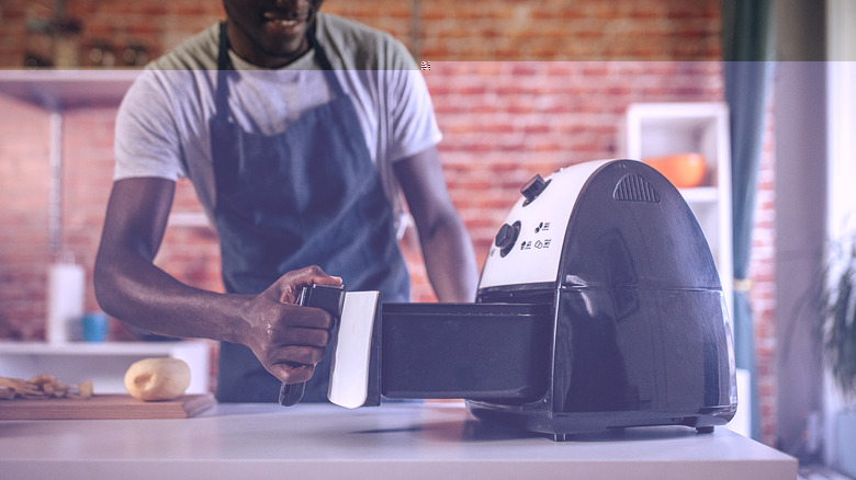 African-American man cooking with air fryer