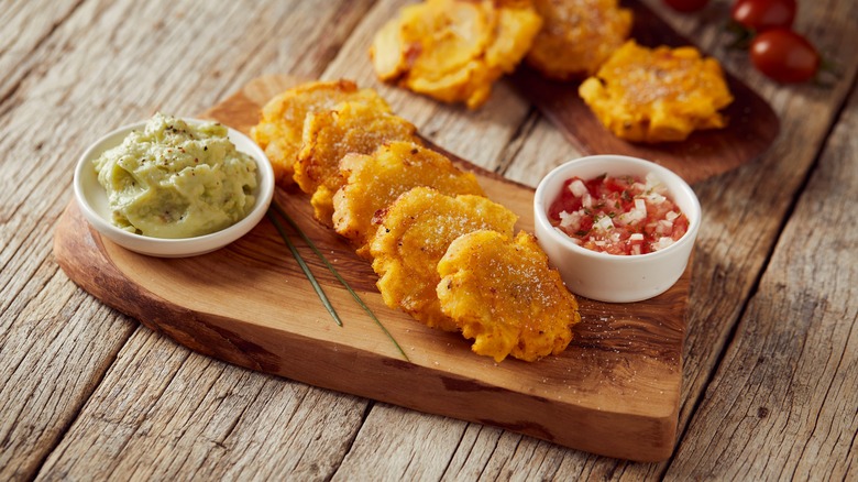 Tostones and sauces on wooden board