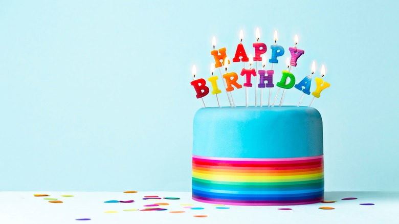 Rainbow cake with happy birthday candles 