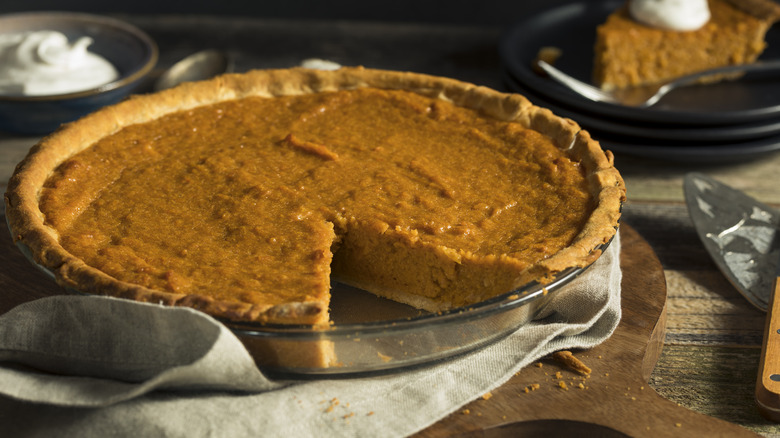Sweet potato pie in pie dish with a slice taken out