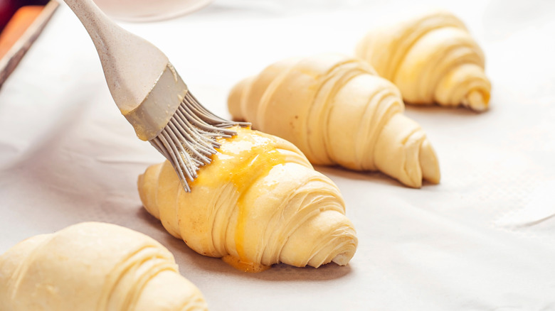 brushing croissant with butter