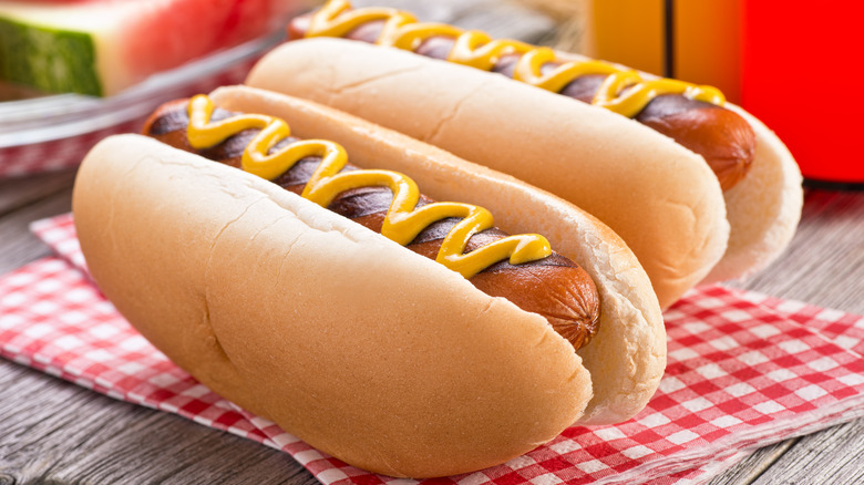 Two hot dogs with mustard