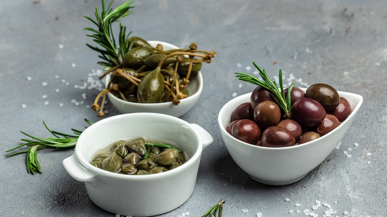 Bowls of capers, green olives, black olives