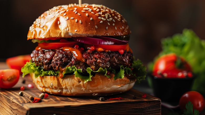 Burger with relish, red onions, and tomatoes.