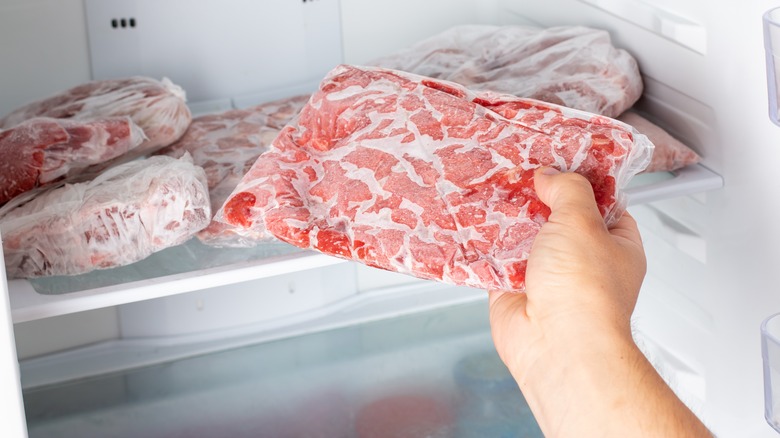 pulling frozen meat from freezer