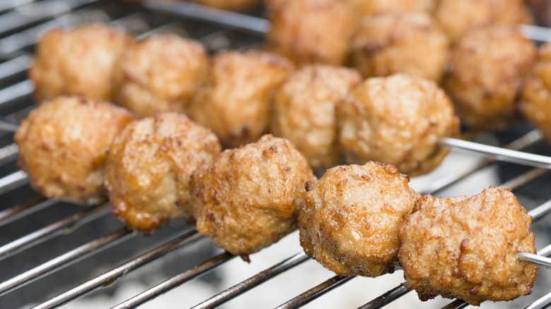 skewered meatballs on a grill