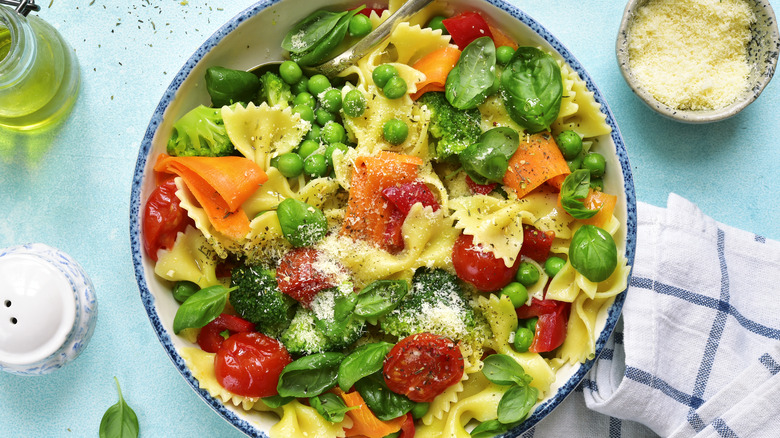 Pasta salad primavera with linens, salt, oil, and cheese