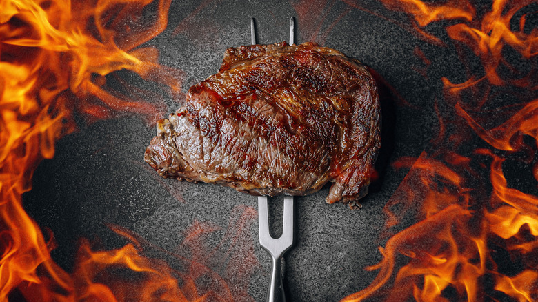 Fire surrounding cooked steak 