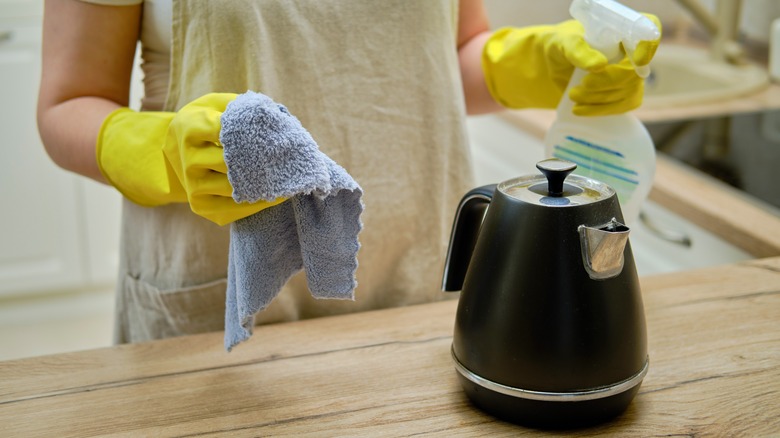 person cleaning teapot 