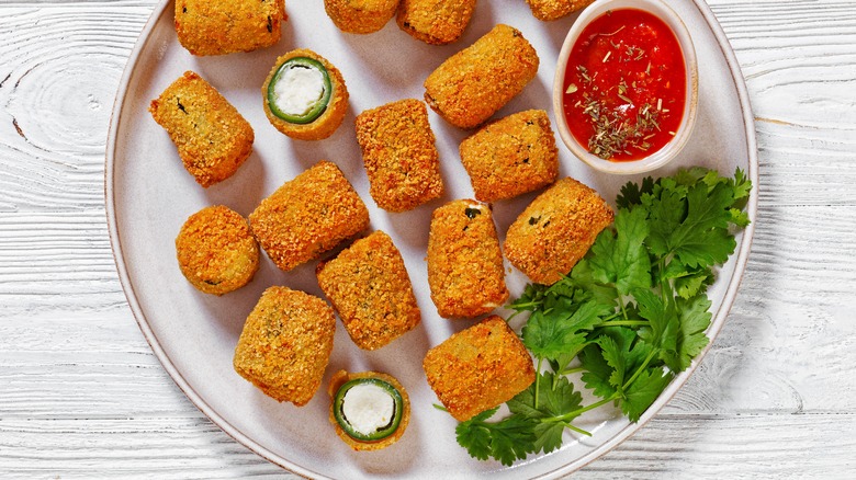 Top down image of jalapeño poppers with dipping sauce