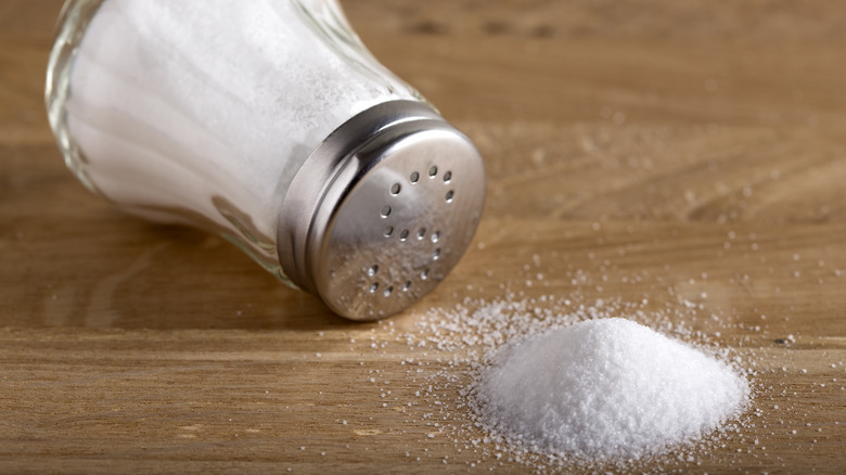 salt shaker laying on side with spilled salt
