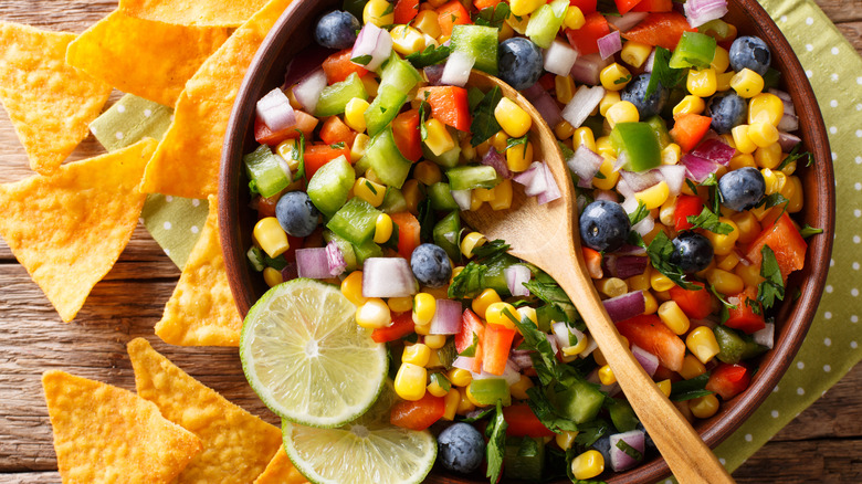 corn and blueberry salsa in bowl with spoon and chips