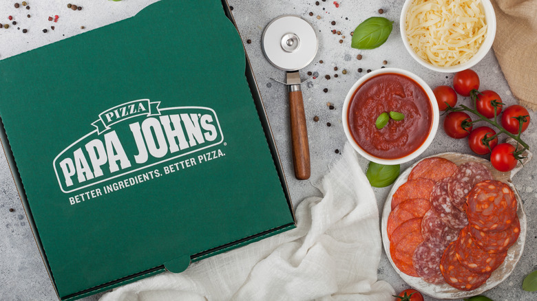 papa johns pizza box surrounded by toppings