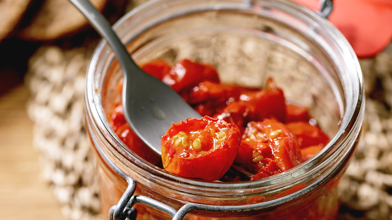 Pulling semi-dried tomatoes from a jar