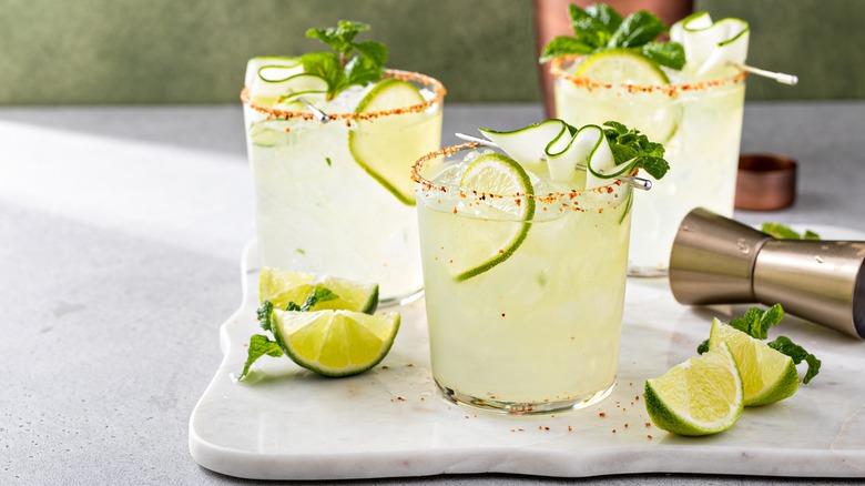margaritas on a tray with limes