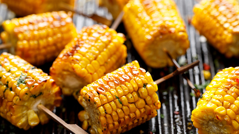 Skewered corn on the cob on grill