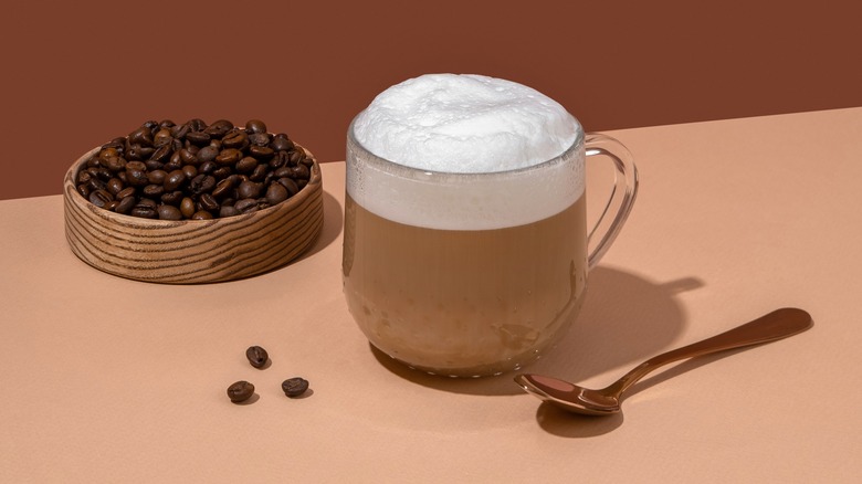 Latte with coffee beans and spoon