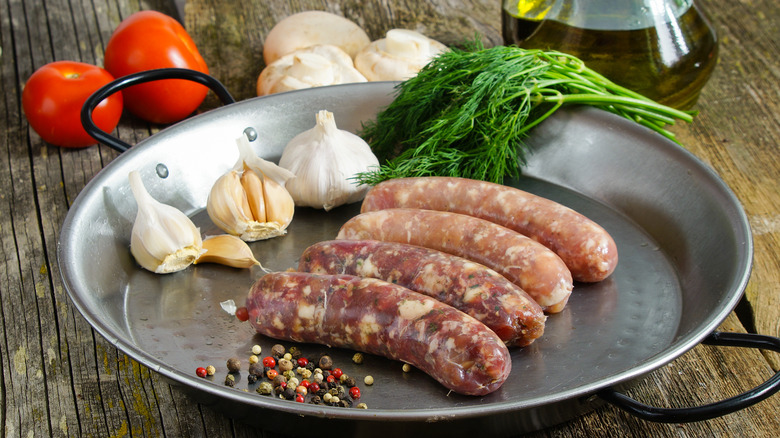 pan with sausages and ingredients