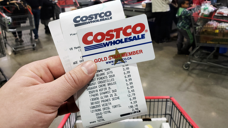 holding Costco card and receipt
