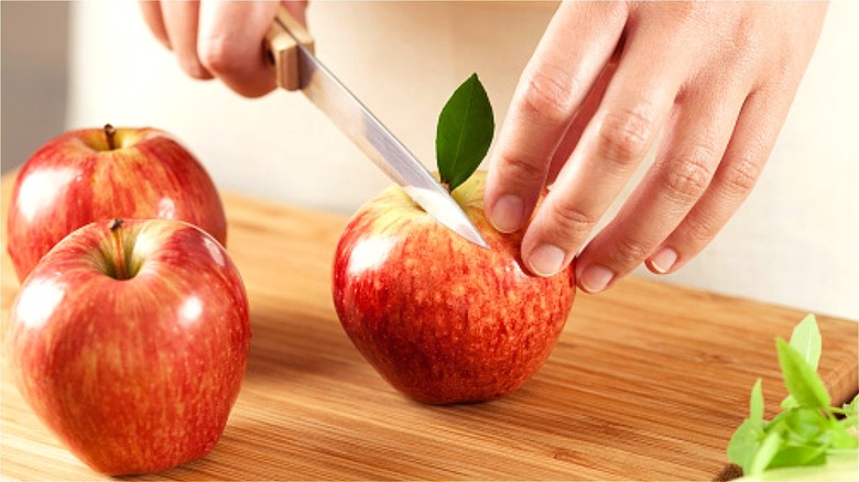 Hands slicing apple