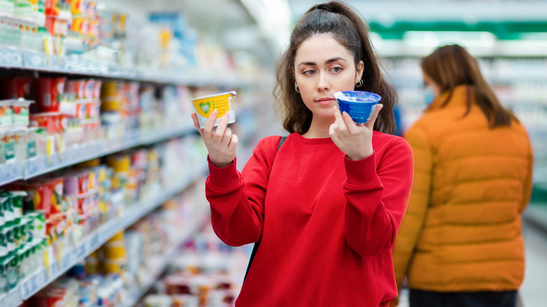 Woman choosing yogurt at store