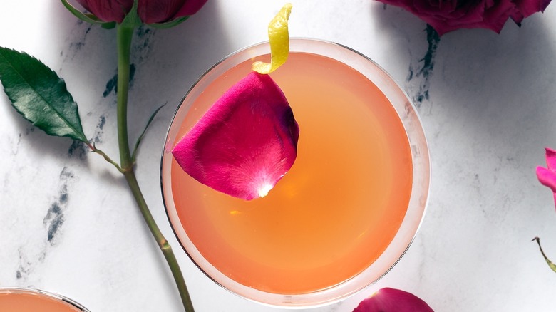 orange cocktail with rose and citrus