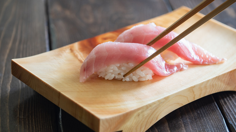 Pair of nigiri-zushi on a wooden plate.