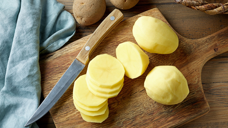 peeled potatoes on cutting board