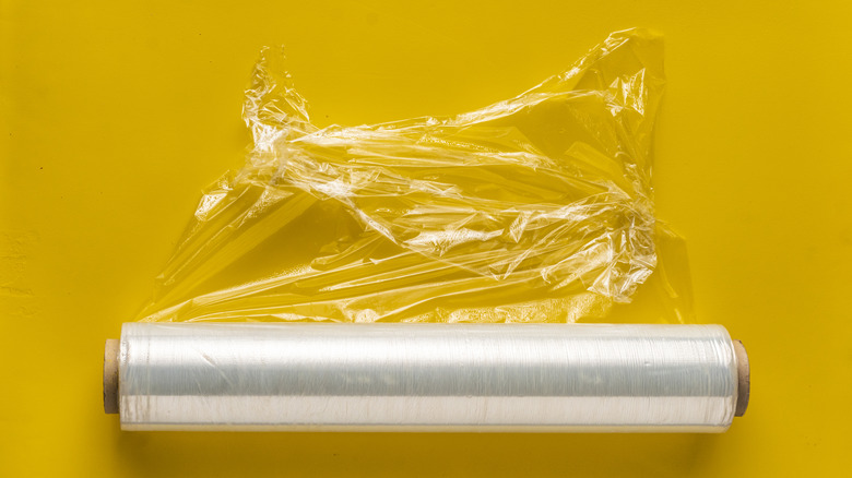 Roll of plastic wrap on a yellow background