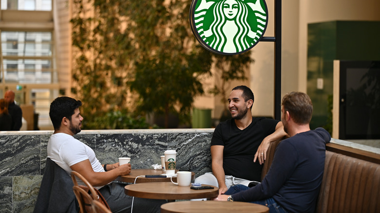 men sitting at Starbucks tables