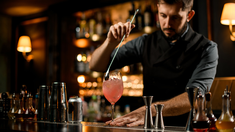bartender mixing pink cocktail