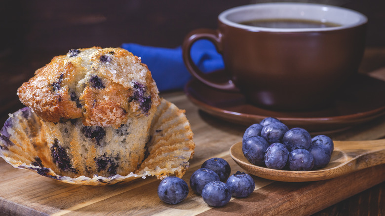 Blueberry muffin near a coffee mug