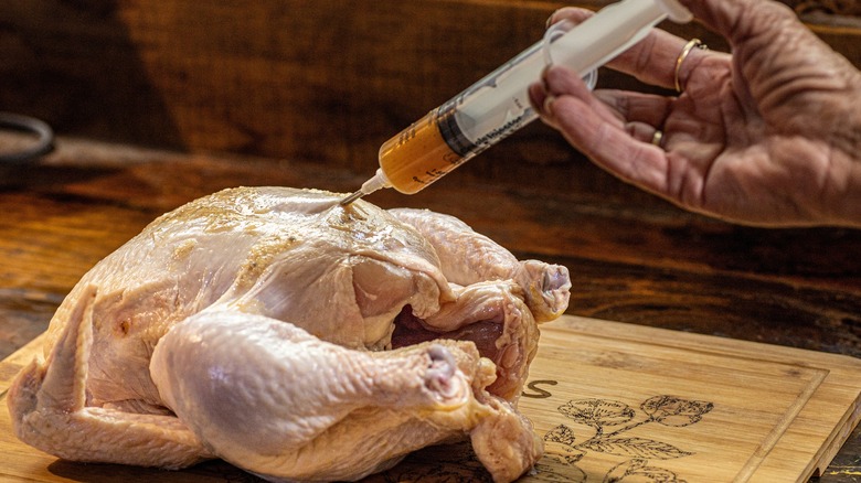 injecting a chicken with marinade