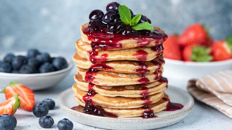 Stack of pancakes with berry topping and mint