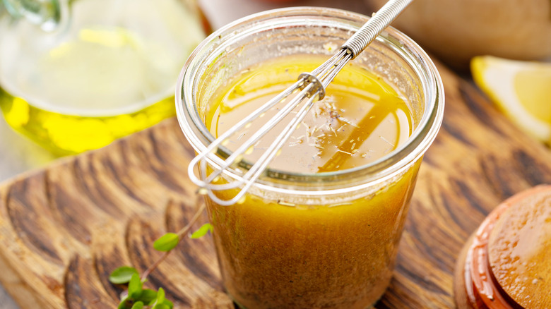 salad dressing in jar with mini whisk resting on top