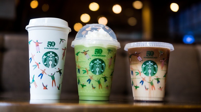 three Starbucks coffee drinks lined up on table