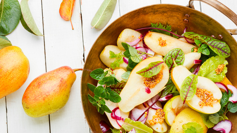 Green salad with pears in a copper bowl