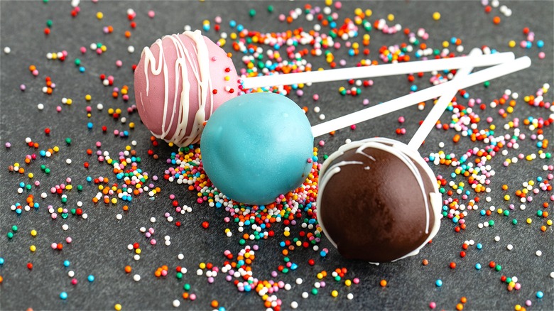 Colorful cake pops on grey surface 