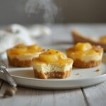 Delicious mini pineapple cheesecake upside bites served on a table with caramelized topping and graham crust.