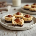 mini rolo cheesecake recipe: : Rich and creamy mini rolo cheesecake recipe topped with caramel chocolate candy on a white background.
