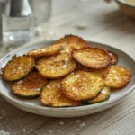 salt and vinegar zucchini chips: : Crispy golden baked salt and vinegar zucchini chips on a tray