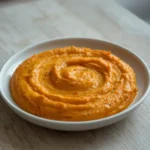 carrot roasted red pepper feta dip: : Creamy carrot roasted red pepper feta dip in a bowl with fresh vegetables