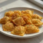 crispy ravioli appetizer: : Crispy air fryer ravioli appetizer on a plate with marinara dip.