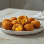Golden crispy homemade mini corndogs with melted cheddar cheese filling on a serving platter