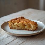 A freshly baked easy apple cake with a golden crust, sliced and ready to serve, showing visible apple pieces and a tender crumb.