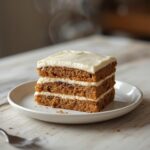 A luxurious latte cake with layered coffee sponge and creamy frosting, served on a table.