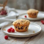 Raspberry and chocolate chip muffins with crumble topping on a baking sheet, a perfect fall dessert.