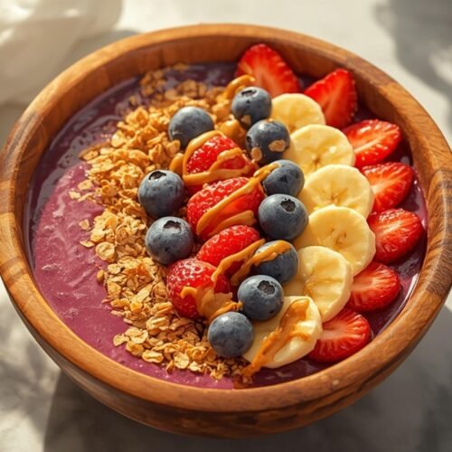 A beautiful and healthy perfect acai bowl, generously topped with fresh fruit and granola, ready to be enjoyed.